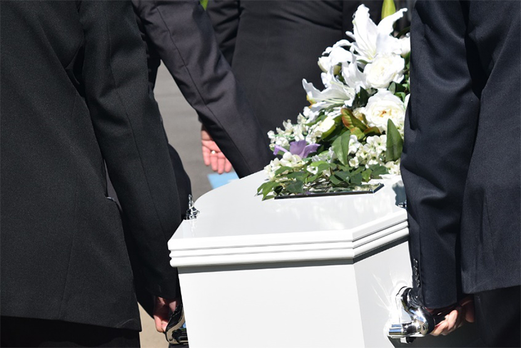 white coffin being carried